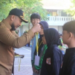 Kepala Disdik Kota Kediri, Anang Kurniawan, saat mengalungkan medali kepada salah satu atlet. Foto: Ist