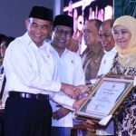 Gubernur Jawa Timur Khofifah Indar Parawansa saat menerima penghargaan dari Menteri Koordinator Bidang Pembangunan Manusia dan Kebudayaan, Muhadjir Effendy didampingi Menteri Desa dan PDTT, Abdul Halim Iskandar di Merlyn Park Hotel, Jakarta, Senin (25/11). foto: istimewa/ bangsaonline.com