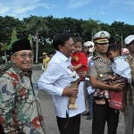 Bupati Sambari HR menggendong salah satu korban. foto: syuhud/ bangsaonline