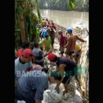 Aksi gotong royong warga dan Pemda setempat memperbaiki tanggul yang rusak. foto: YUDI EP/ BANGSAONLINE