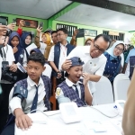 Menko PMK, Pratikno saat berinteraksi dengan salah satu siswa SMP Negeri 1 Padangan Bojonegoro yang mengikuti cek kesehatan gratis