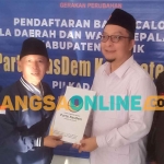 Ketua Desk Pilkada NasDem Gresik, Irfan Choirie, saat menerima pendaftaran dari Asluchul Alif. Foto: SYUHUD/BANGSAONLINE
