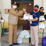 Camat Tambak Agung Endro saat menyerahkan bantuan. foto: ist.