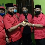 Ketua DPC PDIP Kabupaten Kediri, Murdi Hantoro (dua dari kanan) saat menerima potongan nasi tumpeng dari Ketua PAC PDIP Kecamatan Pagu, Sudarji. foto: MUJI HARJITA/ BANGSAONLINE