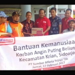 IKUT PEDULI: Alfamart dan PWI Sidoarjo saat menyerahkan bantuan untuk korban puting beliung di Posko Bencana Balai Desa Terungkulon Kecamatan Krian, Sidoarjo, Jumat (17/2). foto: mustain/ BANGSAONLINE.com