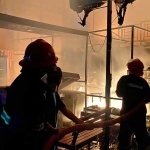 Petugas saat memadamkan api yang membakar Kafe Selon, Pamekasan. 