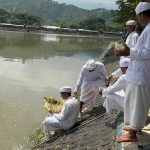 Umat Hindu saat melarung sesaji di Waduk Siman. 