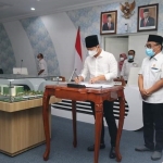 Bupati Trenggalek, Mochamad Nur Arifin, saat menandatangi nota kesepakatan dana pinjaman. Foto: HERMAN SUBAGYO/ BANGSAONLINE.com
