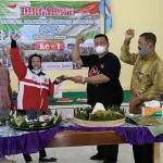 Ketua DPRD Kabupaten Kediri, Dodi Purwanto, saat menerima potongan nasi tumpeng dari Ketua NPCI Kabupaten Kediri, Lilik Kumaidah. Foto: MUJI HARJITA/ BANGSAONLINE