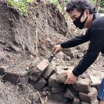 Nino Subekti, saat menunjukkan tumpukan batu bata kuno yang diduga sebagai objek cagar budaya. (foto: MUJI HARJITA/ BANGSAONLINE)