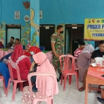 Babinsa Koramil 0826-04 Galis, Kabupaten Pamekasan, saat mendampingi warga ketika vaksinasi Covid-19 di Balai Desa Pagendingan.
