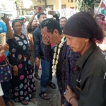 Abdul Wahab dikalungi bunga, disiram kembang 7 rupa, dan disambut tari pencak macan. foto: SYUHUD/ BANGSAONLINE