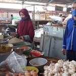 Soewardi, Koordinator Pasar Pahing, Kota Kediri, saat mengecek lapak milik salah satu pedagang. (foto: muji harjita/ bangsaonline)