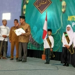 Wakil Ketua IV Baznas Jatim, KH Husnul Khuluq, saat memberikan beasiswa secara simbolis kepada salah satu siswa/santri berprestasi. Foto: Ist