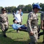 Petugas medis menggotong korban yang pingsan saat mengikuti upacara hari lahir pancasila di Alun-Alun Kabupaten Jombang, Kamis (1/6/2017). foto: ROMZA/ BANGSAONLINE
