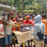 Proses evakuasi jenazah korban oleh petugas dibantu warga.  