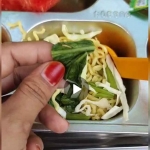 Tangkapan layar video yang menunjukkan ulat kecil di atas sayur sawi pada menu MBG yang dihidangkan untuk siswa SDN 1 Compreng.