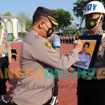 Kapolres Gresik, AKBP Mochamad Nur Azis, mencoret foto Bripka Deni Rahmat dengan tinta merah sebagai tanda pemberhentian dari dinas Polri. Foto: SYUHUD/BANGSAONLINE.