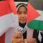  Seorang perempuan memegang Bendera Indonesia & Palestina saat aksi solidaritas mengutuk penyerangan Masjid Al-Aqsa oleh Israel di Jakarta, Jumat (14/11/2014). Foto: Vivanews.com