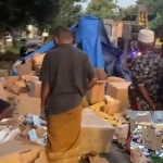 Tangkapan layar saat warga menyingkirkan muatan rokok yang tumpah ke tepian jalan