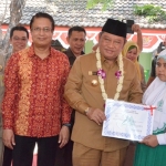 SIMBOLIS: Bupati Sidoarjo H Saiful Ilah menyerahkan beasiswa PT Megasurya Mas kepada siswa, di SDN Tambaksawah, Waru, Senin (6/8). Foto: ist