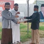 R. Imron Amin (kiri) bersama Syafiuddin menyerahkan sembako bersama secara simbolis kepada masyarakat terdampak Covid-19. foto: FAUZI/ BANGSAONLINE