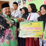 Bupati Madiun Muhtarom saat memberikan penghargaan dalam perayaan Hari Guru Nasional. foto: HENDRO/ BANGSAONLINE