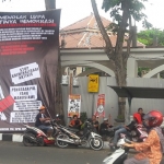 Spanduk raksasa berisikan penolakan revitalisasi Alun-alun dipasang di pinggir Alun-alun. Foto: SYUHUD A/BANGSAONLINE.