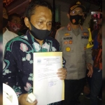 Aris Wibawa, Sekretaris Dewan Lamongan didampingi Kapolres Lamongan AKBP Harun saat menunjukan surat pembatalan paripurna.