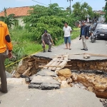 Petugas dibantu warga membuat jembatan sementara dari kayu untuk para pejalan kaki.