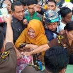 Kajari Sidoarjo HM Sunarto SH (pakaian safari) beserta istri Hj Yuli Sunarto (kerudung kuning) serta jaksa yang lain saat membagikan takjil kepada warga yang sudah berjubel mengantri. foto: NANANG I/ BANGSAONLINE