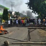 Massa aksi yang tergabung dalam Persatuan Tumangan Gunung Sadeng saat membakar ban di tengah jalan.