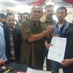 Sunarto dan dua pimpinan DPRD Kota Mojokerto yang lain mengangkat tanda tangan berisi petisi penolakan perubahan UU KUHP dan UU KPK. Nantinya petisi di atas materai ini akan diteruskan ke DPR RI. (foto: YUDI EP/ BANGSAONLINE)