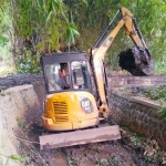 Alat berat jenis backhoe milik Pemkab Pasuruan saat melakukan normalisasi.