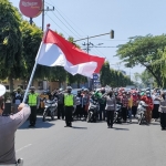 Selasa (17/8) tepat pukul 10.17 WIB, pengguna jalan di depan Mako Satlantas Polres Kediri Kota Jalan Brawijaya, Kota Kediri, berhenti untuk melaksanakan penghormatan kepada Bendera Merah Putih dan menyanyikan lagu Indonesia Raya yang dipandu oleh petugas Satlantas Polres Kediri Kota. foto: MUJI HARJITA/BANGSAONLINE