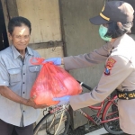 Salah satu anggota Polwan Polresta Sidoarjo saat menyerahkan paket sembako.