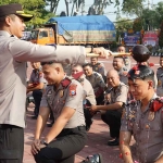 Kapolres Gresik AKBP Rovan Richard Mahenu saat menyiramkan air kembang kepada anggota yang naik pangkat. Foto: Ist