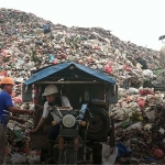 Devi Rosyida Ariyani (30) dengan motor gerobak tuanya saat membuang sampah di TPA Ngipik. Foto: SYUHUD/ BANGSAONLINE