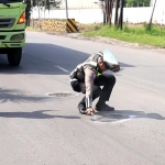 Petugas Satlantas Polres Gresik menandai jalan berlubang di Jalan Raya Daendels. Foto: Ist.