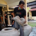 Petugas dari Dinas Pariwisata dan Kebudayaan Kabupaten Kediri saat menyelamatkan cagar budaya. Foto: Ist