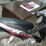 Tersangka pembunuh Metty alias Slamet Pujianto (di balik motor) dengan kaki kanan terbalut akibat berusaha kabur. Petugas juga mengamankan barang bukti berupa sangkur berada di atas meja.