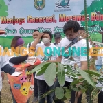 Wali Kota Madiun, Maidi, saat mendampingi orang tua bayi untuk menanam pohon. Foto: HENDRO SUHARTONO/BANGSAONLINE