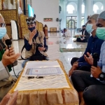Tangguh Fajar Anugrah (kanan) saat dibimbing KH Abdul Hamid Abdullah, Imam Masjid Nasional Al-Akbar Surabaya, membaca dua kalimat syahadat. foto: mma/ bangsaonline.com
