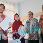 Orang tua Zia Raihana Arief menunjukkan akta kelahiran dan KK gratis dari program Alamak, di RSUD Sidoarjo, Kamis (9/3). foto: mustain/ BANGSAONLINE.com
