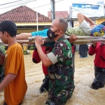 Personel TNI dari Kodim 0826/Pamekasan saat mengevakuasi korban banjir.