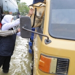 Gubernur Jawa Timur, Khofifah Indar Parawansa saat meninjau luapaan banjir di Sampang menyapa seorang sopir truks dengan memberikan masker dan sembako, Ahad (20/12/2020). foto: ist.