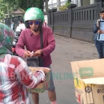 Sejumlah pengendara tampak turut menyumbang uang koin dalam aksi yang digelar di depan gedung DPRD Kota Malang, Kamis (21/03). foto: IWAN IRAWAN/ BANGSAONLINE