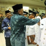 Bupati Sambari didampingi Wabup Moh. Qosim menyematkan pin kepada kades usai dilantik. foto: SYUHUD/ BANGSAONLINE