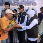 Gubernur Jawa Timur, Khofifah Indar Parawansa, didampingi Bupati Tuban, Aditya Halindra, saat menyerahkan sembako murah pada masyarakat Kabupaten Tuban.