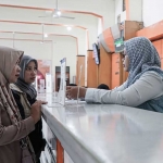 Petugas Kantor Pos Kediri saat melayani keluarga penerima manfaat yang mencairkan bantuan PPSE. Foto: Ist.